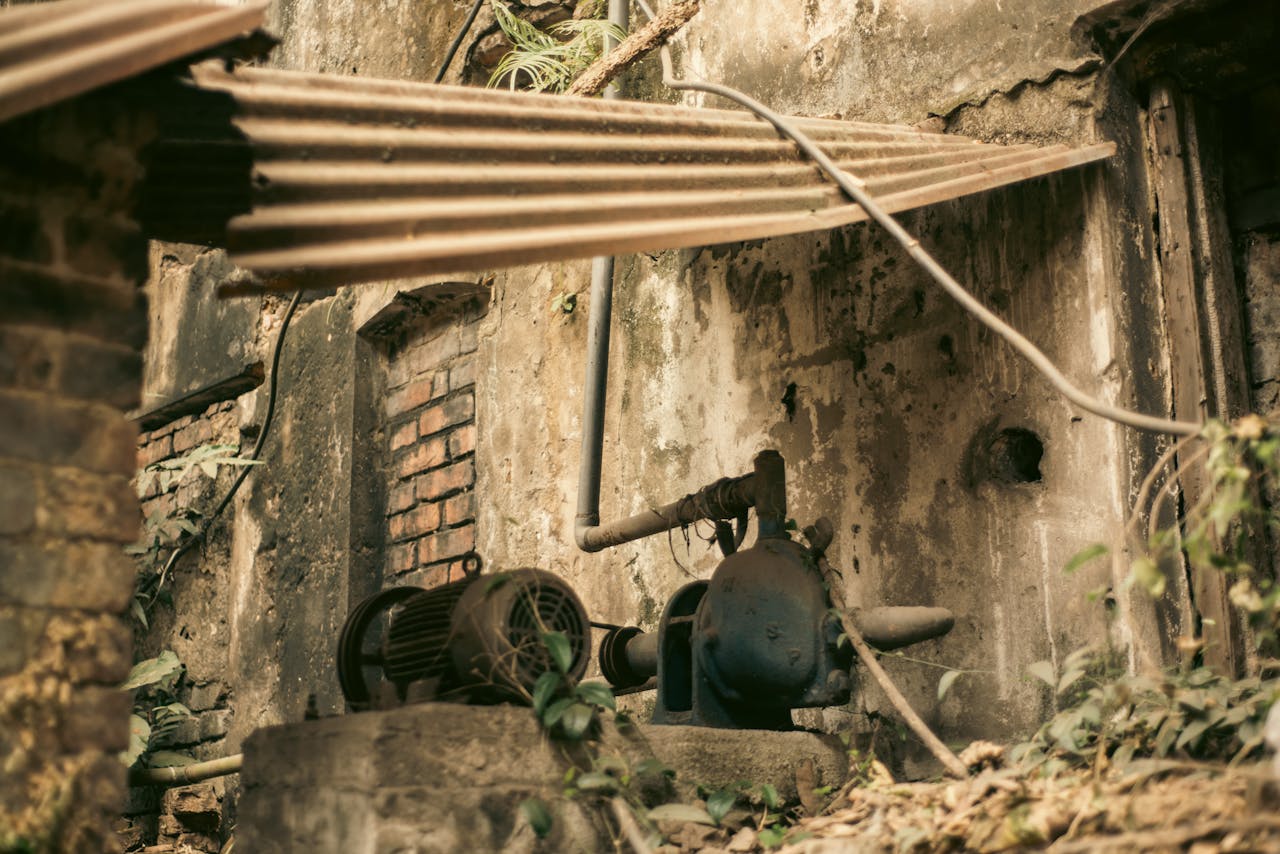 Aged industrial machinery in an abandoned outdoor setting with weathered textures.